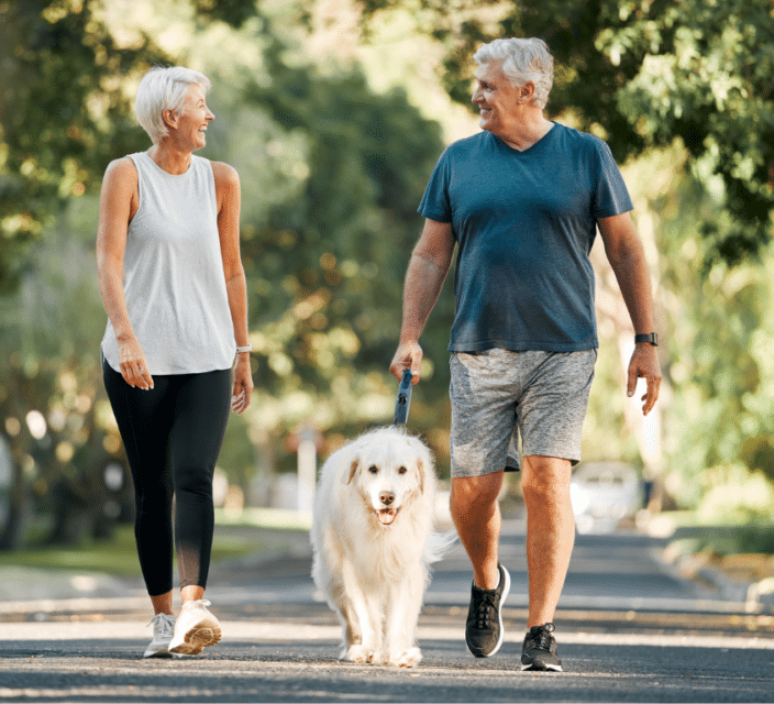 Man and Women enjoying a walk with their dog.